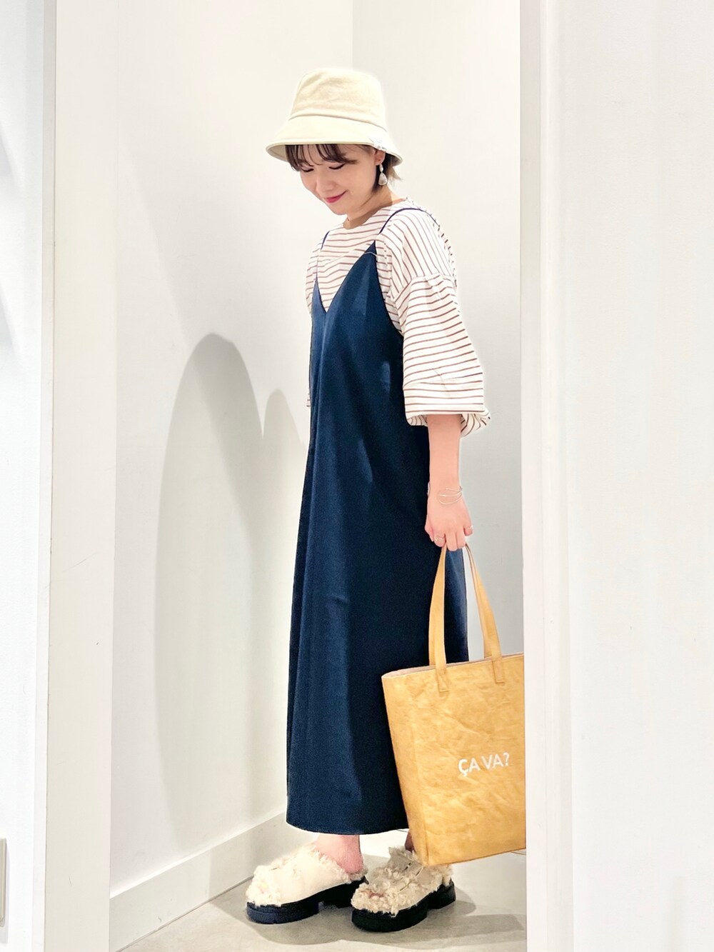 ブルー系のワンピース、ベージュ系のトートバッグ、ベージュ系のサンダルを着用したレディースの夏コーディネートの2枚目の写真