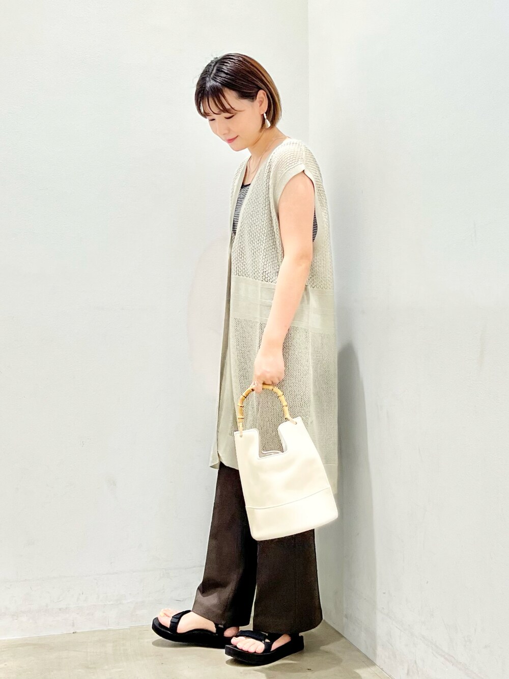 グレー系のベスト、その他のタンクトップ、ブラウン系のその他パンツを着用したレディースの夏コーディネートの2枚目の写真