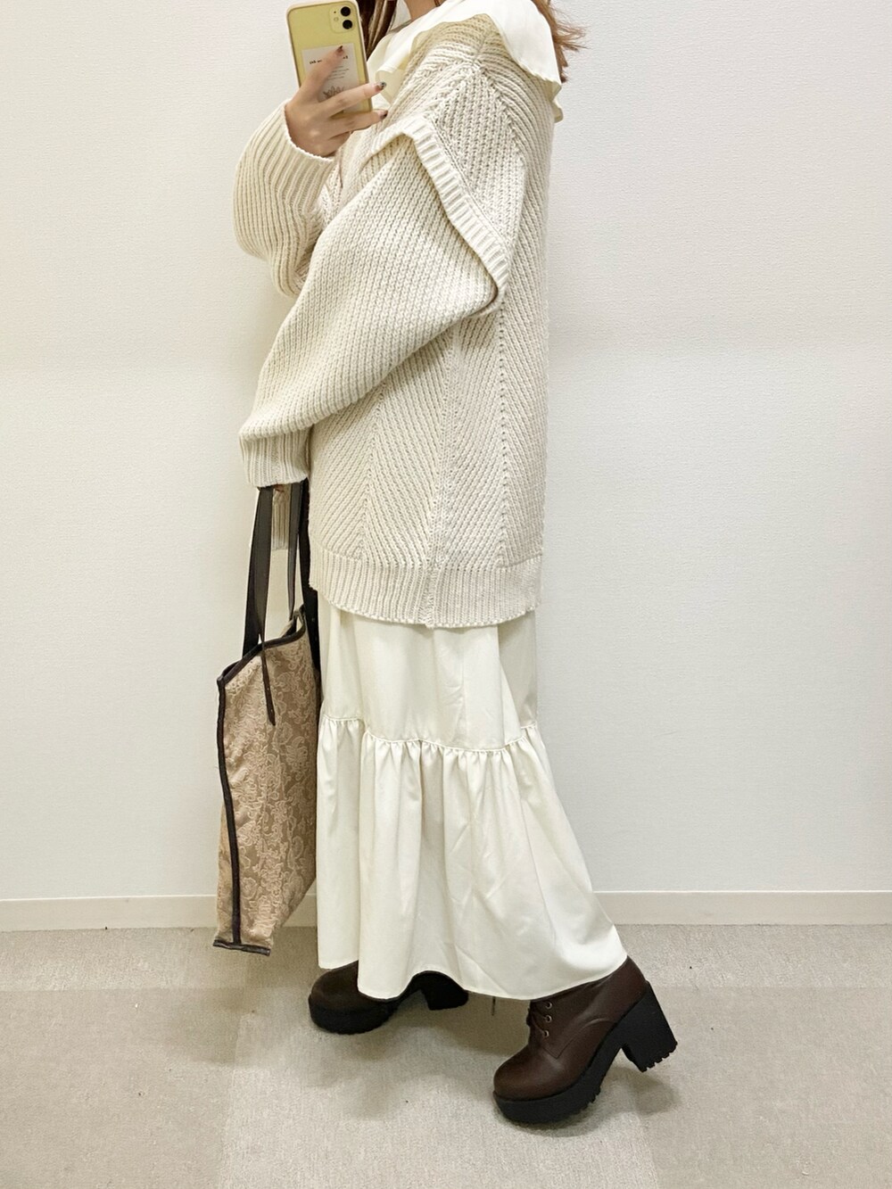 ホワイト系のワンピース、ブラウン系のブーツ、ブラウン系のトートバッグを着用したレディースの冬コーディネートの3枚目の写真