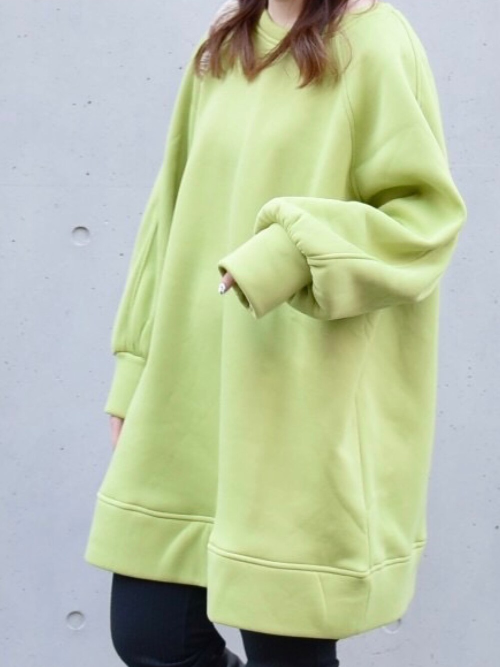 グリーン系のスウェット、ブラック系のブーツを着用したレディースの春コーディネートの2枚目の写真