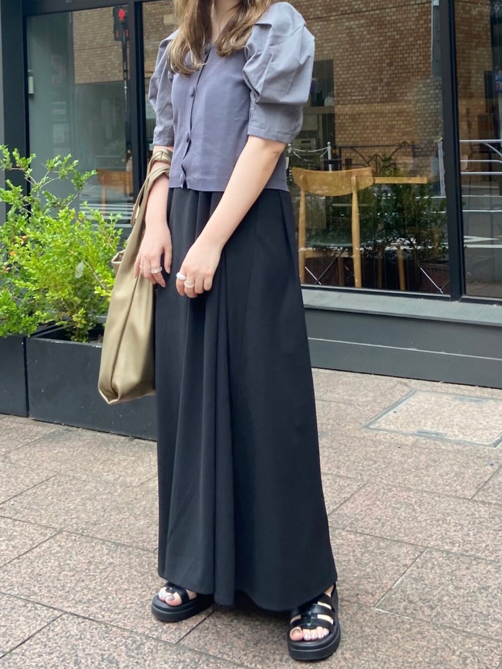 ブラック系のサンダル、ゴールド系のトートバッグ、ピンク系のニット/セーターを着用したレディースの夏コーディネートの2枚目の写真