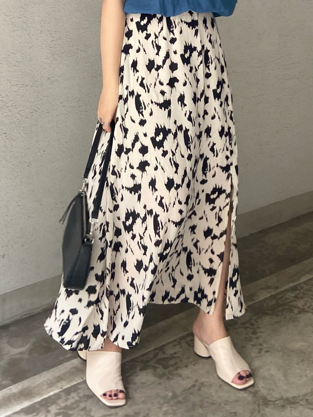 ブルー系のTシャツ/カットソー、ホワイト系のスカート、ホワイト系のサンダルを着用したレディースの夏コーディネートの3枚目の写真