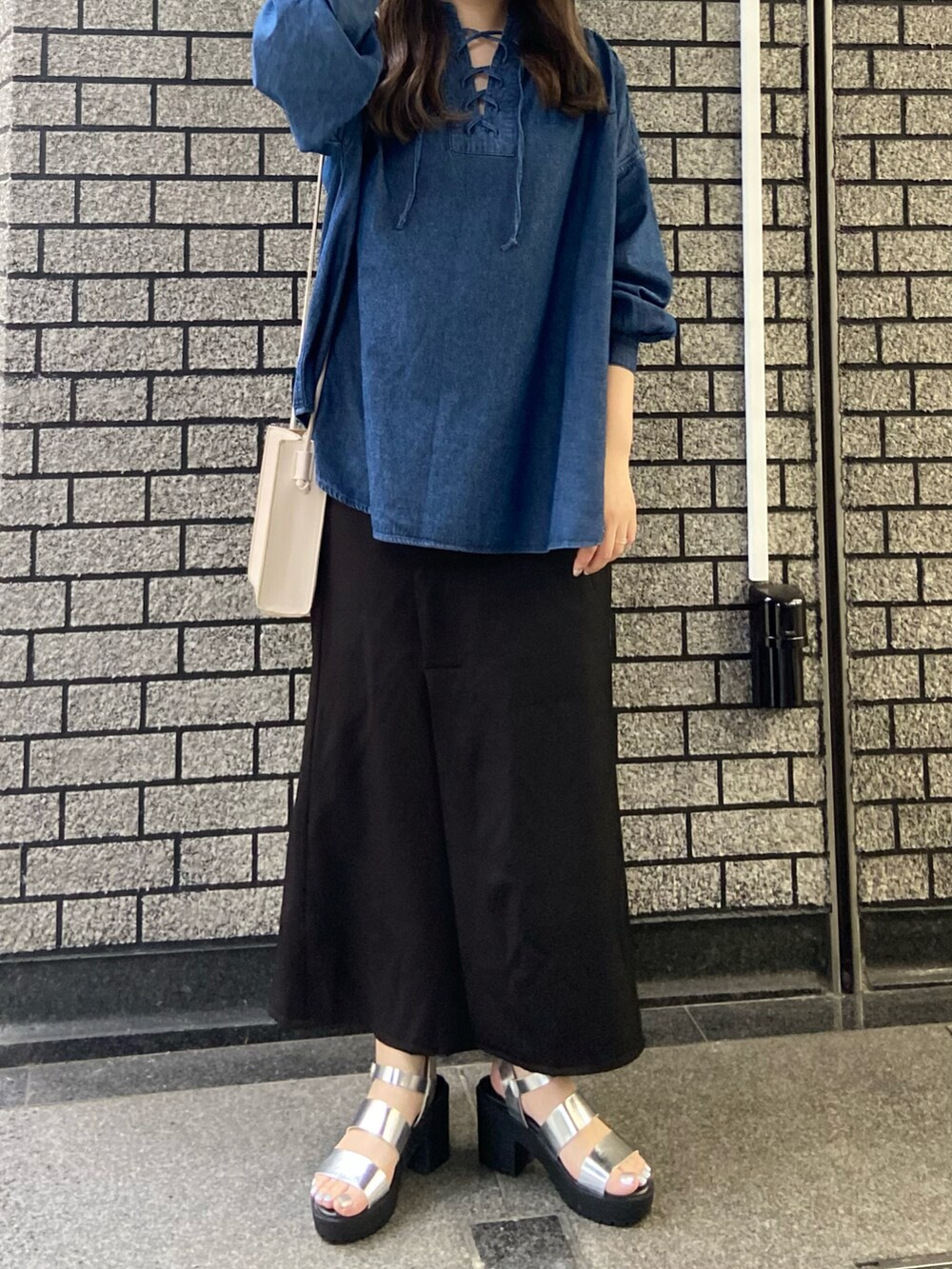 ブルー系のシャツ/ブラウス、ブラック系のスカート、シルバー系のサンダルを着用したレディースの夏コーディネートの2枚目の写真