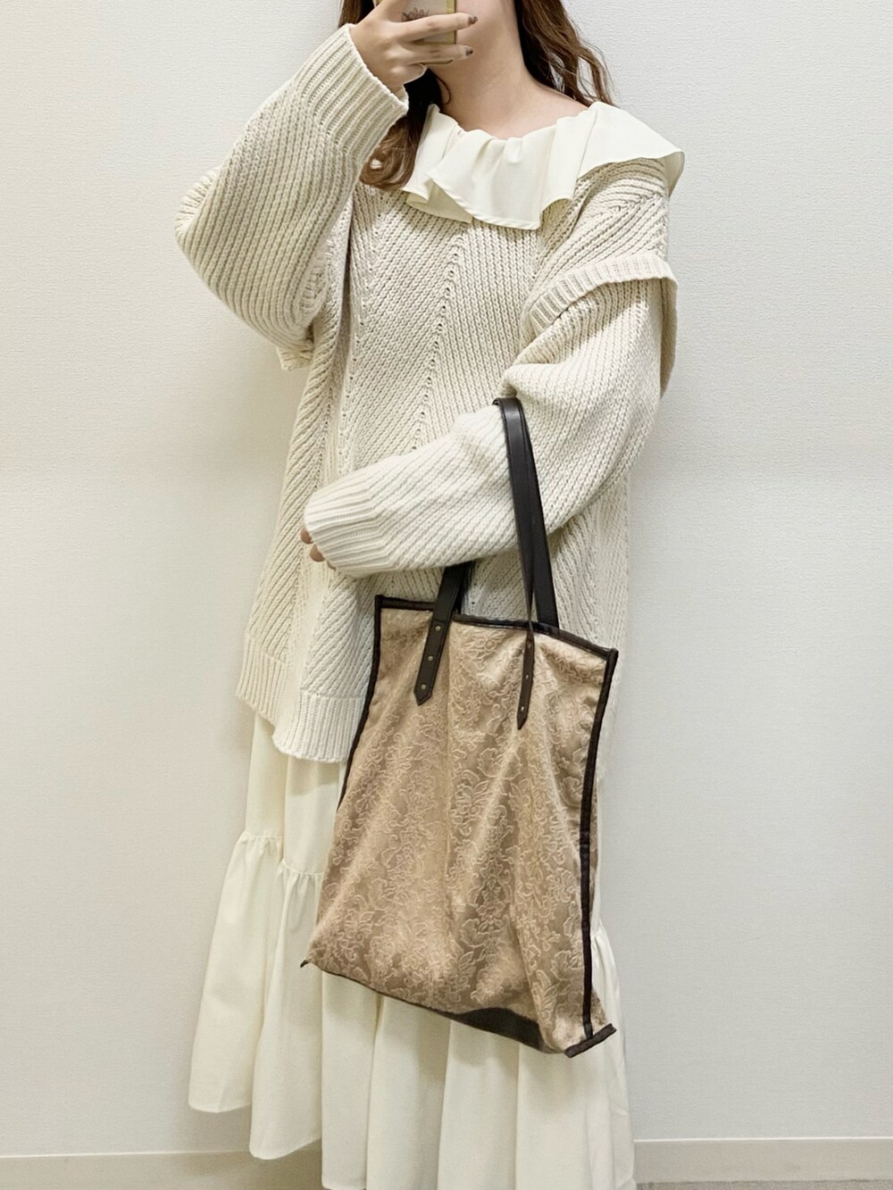 ホワイト系のワンピース、ブラウン系のブーツ、ブラウン系のトートバッグを着用したレディースの冬コーディネートの2枚目の写真