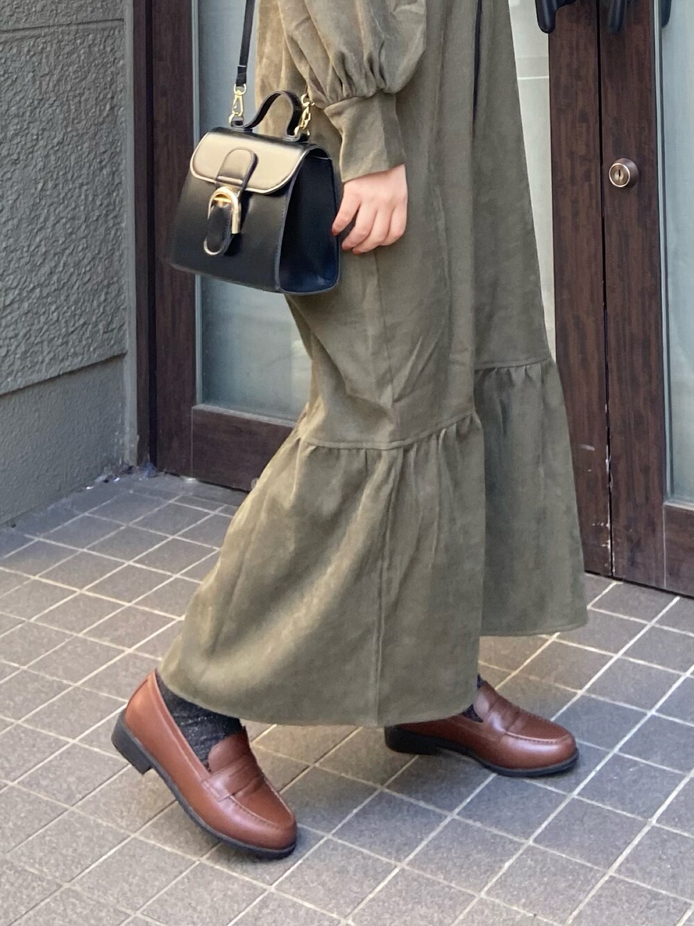 ブラウン系のローファー、グリーン系のワンピースを着用したレディースの冬コーディネートの3枚目の写真