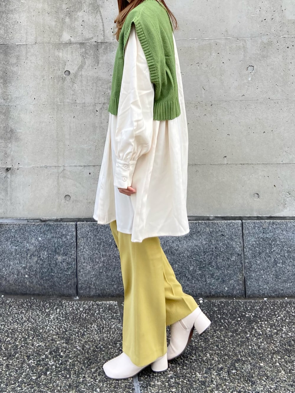 グリーン系のベスト、イエロー系のその他パンツ、ホワイト系のシャツワンピースを着用したレディースの春コーディネートの3枚目の写真