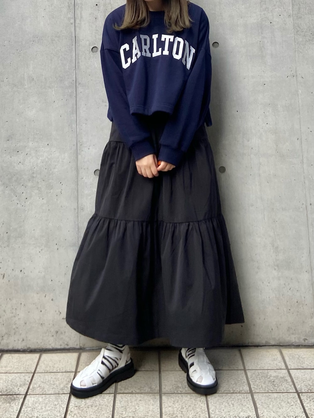 ホワイト系のサンダル、グレー系のスウェット、ブラック系のスカートを着用したレディースの冬コーディネートの2枚目の写真