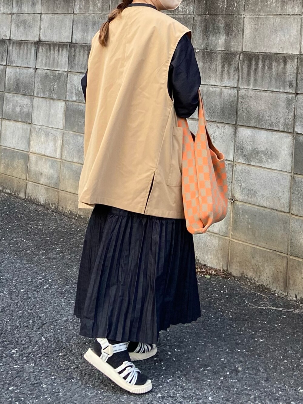 ブルー系のワンピース、ベージュ系のステンカラーコート、ホワイト系のサンダルを着用したレディースの春コーディネートの3枚目の写真