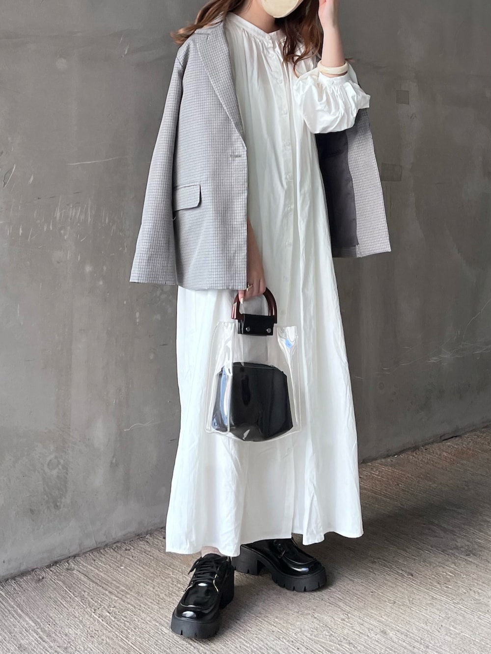 グレー系のテーラードジャケット、ホワイト系のシャツワンピース、ブラック系のドレスシューズを着用したレディースの春コーディネートの3枚目の写真