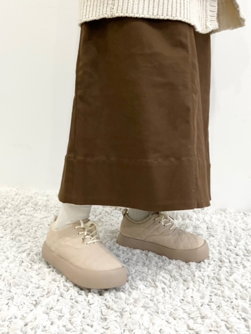 ベージュ系のスニーカーを着用したレディースの秋コーディネートの2枚目の写真