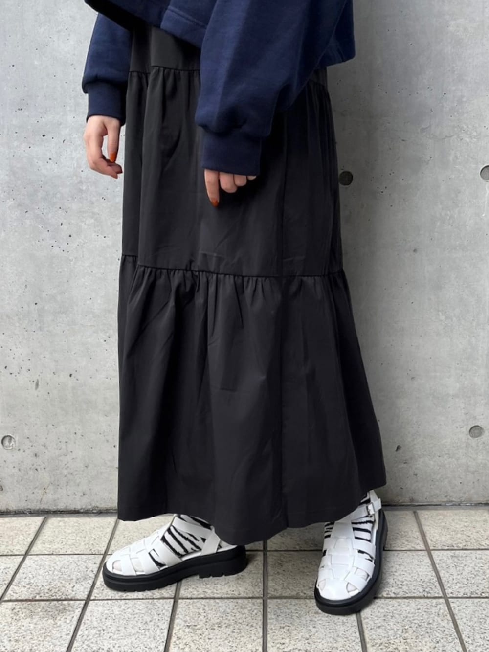 ホワイト系のサンダル、グレー系のスウェット、ブラック系のスカートを着用したレディースの冬コーディネートの4枚目の写真