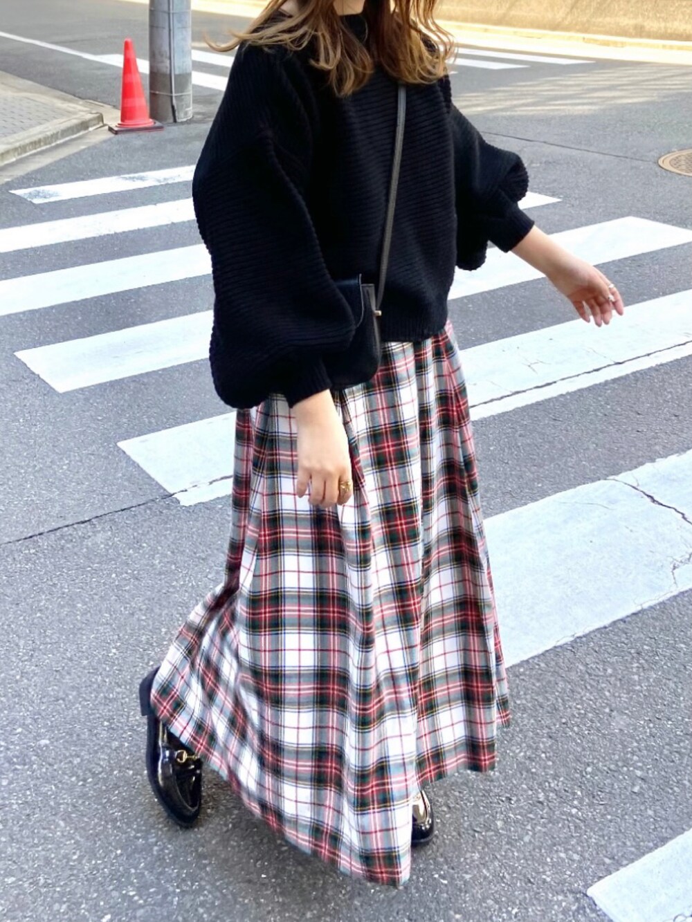 ホワイト系のスカート、ブラック系のローファーを着用したレディースの春コーディネートの2枚目の写真