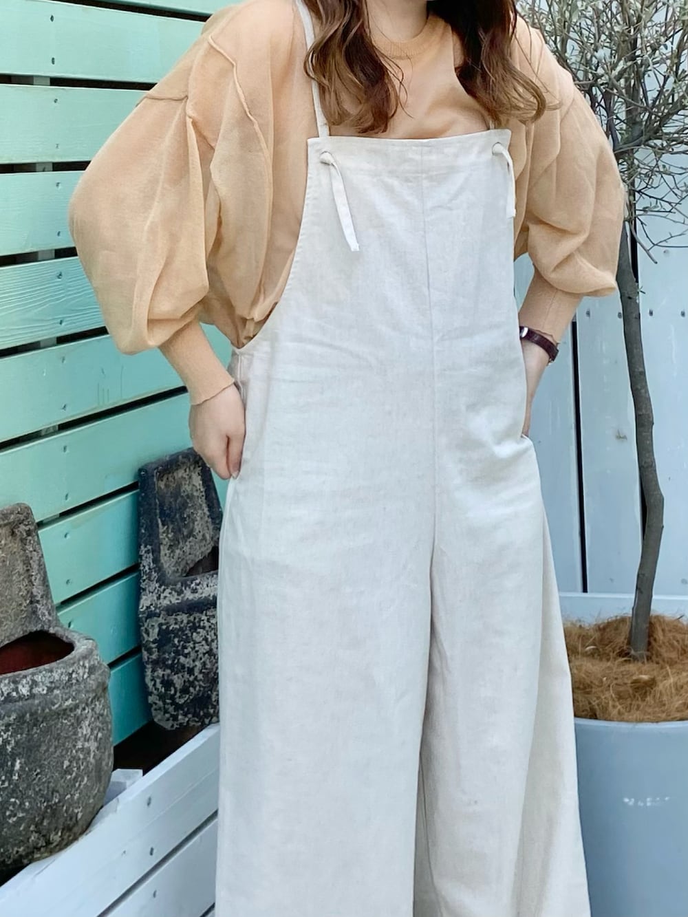 オレンジ系のTシャツ/カットソー、ホワイト系のサロペット/オーバーオールを着用したレディースの春コーディネートの3枚目の写真