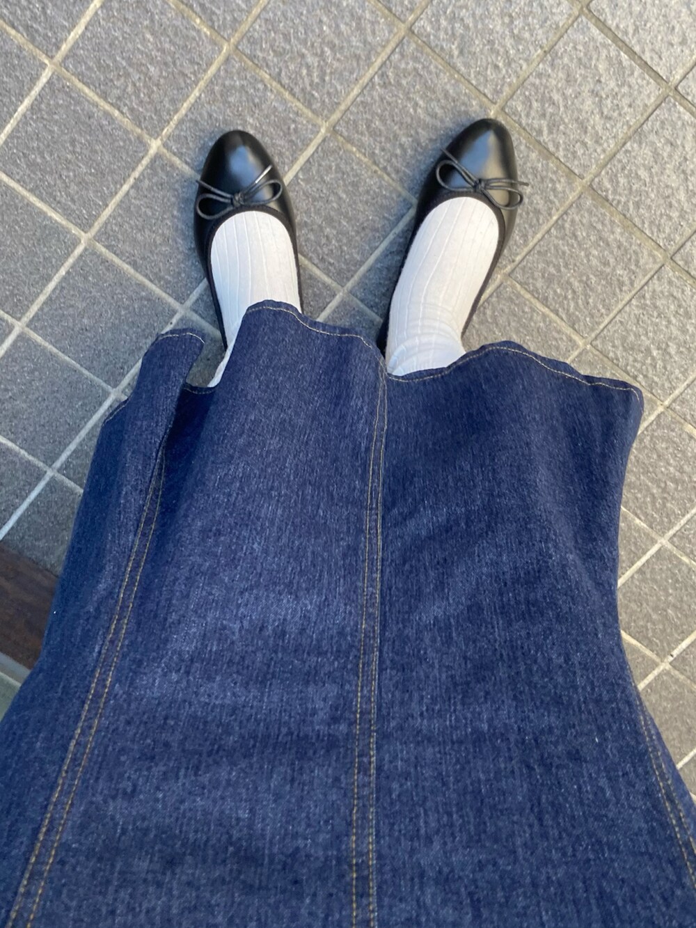 ホワイト系のニット/セーター、ブルー系のスカート、ブラック系のバレエシューズを着用したレディースの春コーディネートの2枚目の写真