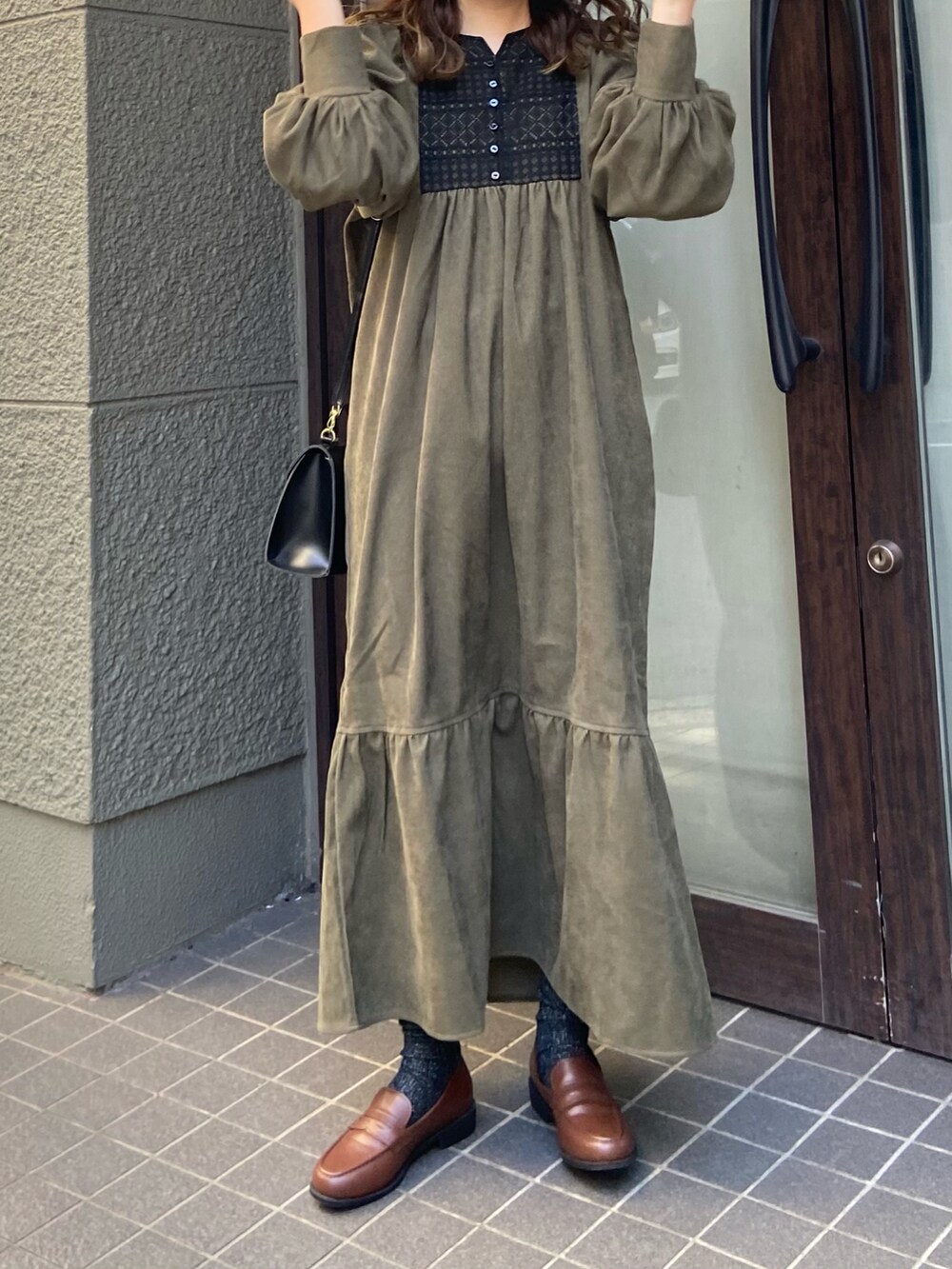 ブラウン系のローファー、グリーン系のワンピースを着用したレディースの冬コーディネートの2枚目の写真