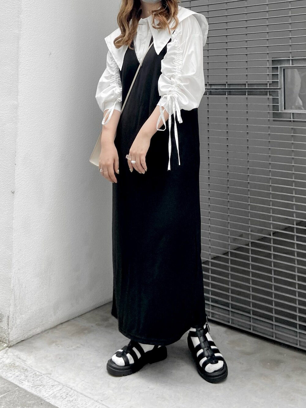 ホワイト系のシャツ/ブラウス、ブラック系のワンピース、ブラック系のサンダルを着用したレディースの夏コーディネートの3枚目の写真
