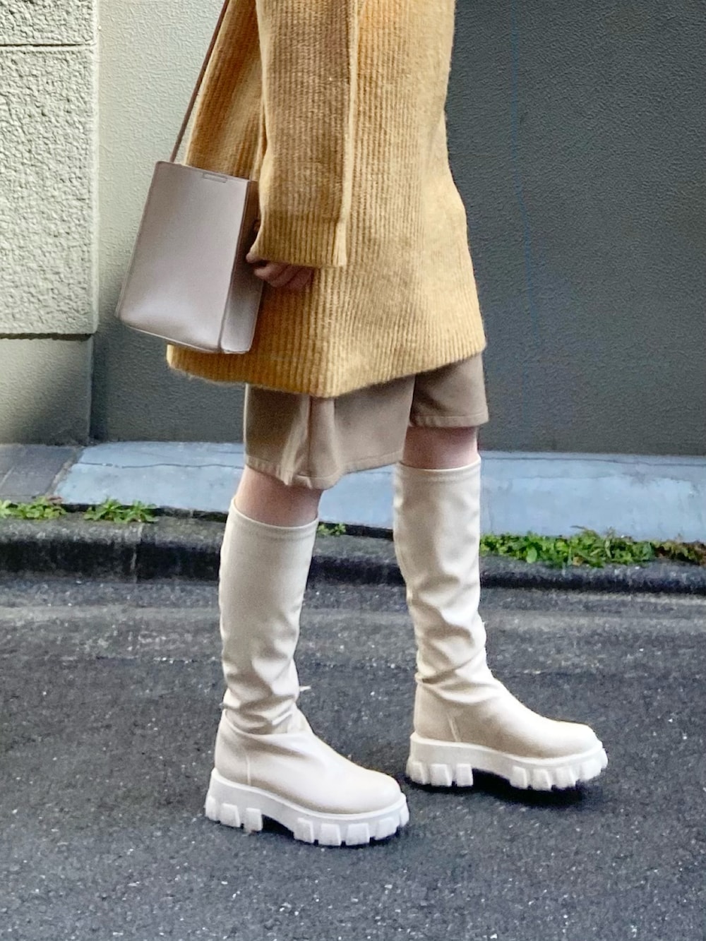 イエロー系のニット/セーター、ベージュ系のその他パンツ、ベージュ系のブーツを着用したレディースの冬コーディネートの4枚目の写真