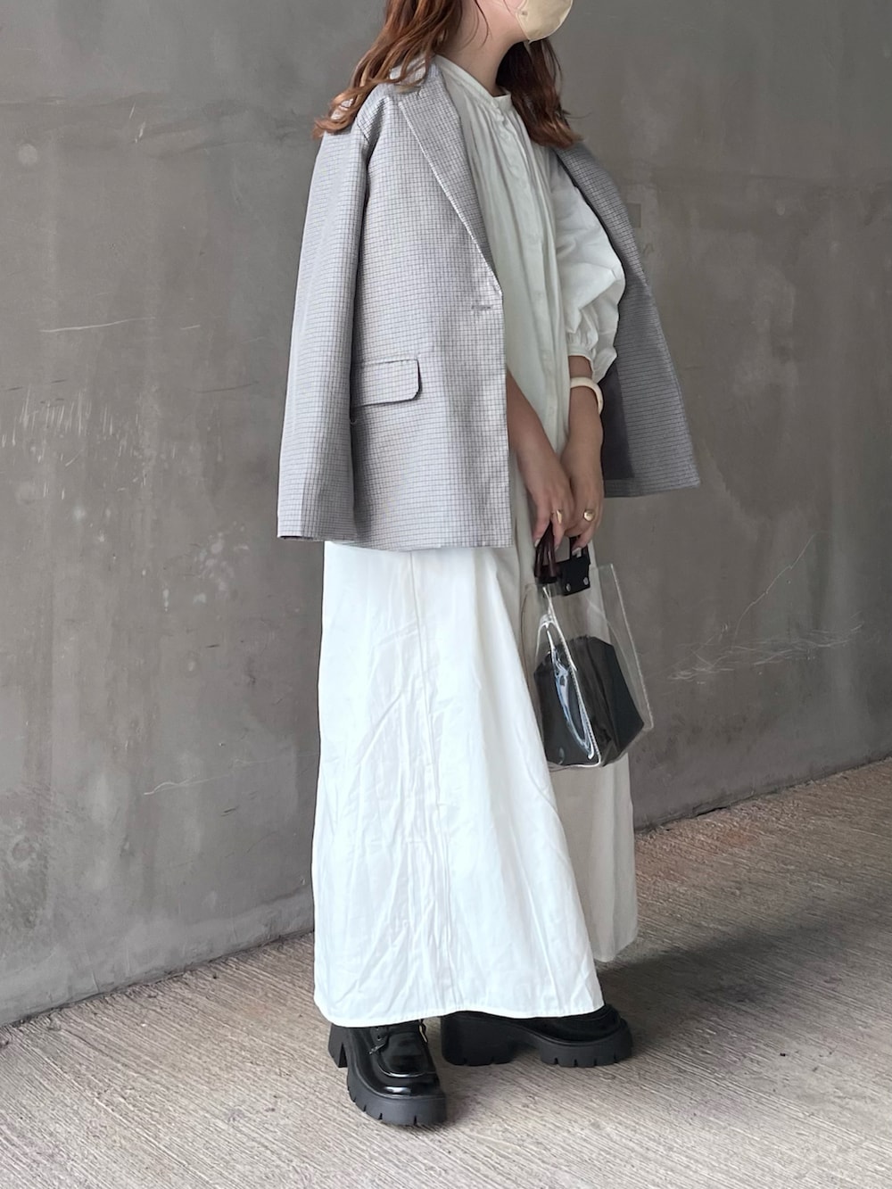 グレー系のテーラードジャケット、ホワイト系のシャツワンピース、ブラック系のドレスシューズを着用したレディースの春コーディネートの2枚目の写真