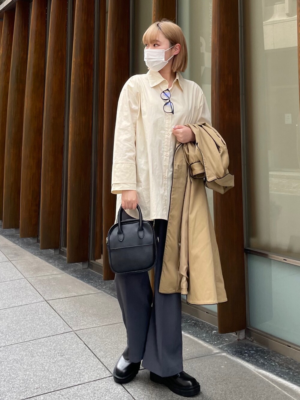 ベージュ系のトレンチコート、ホワイト系のシャツ/ブラウス、ブラック系のシューズを着用したレディースの春コーディネートの2枚目の写真