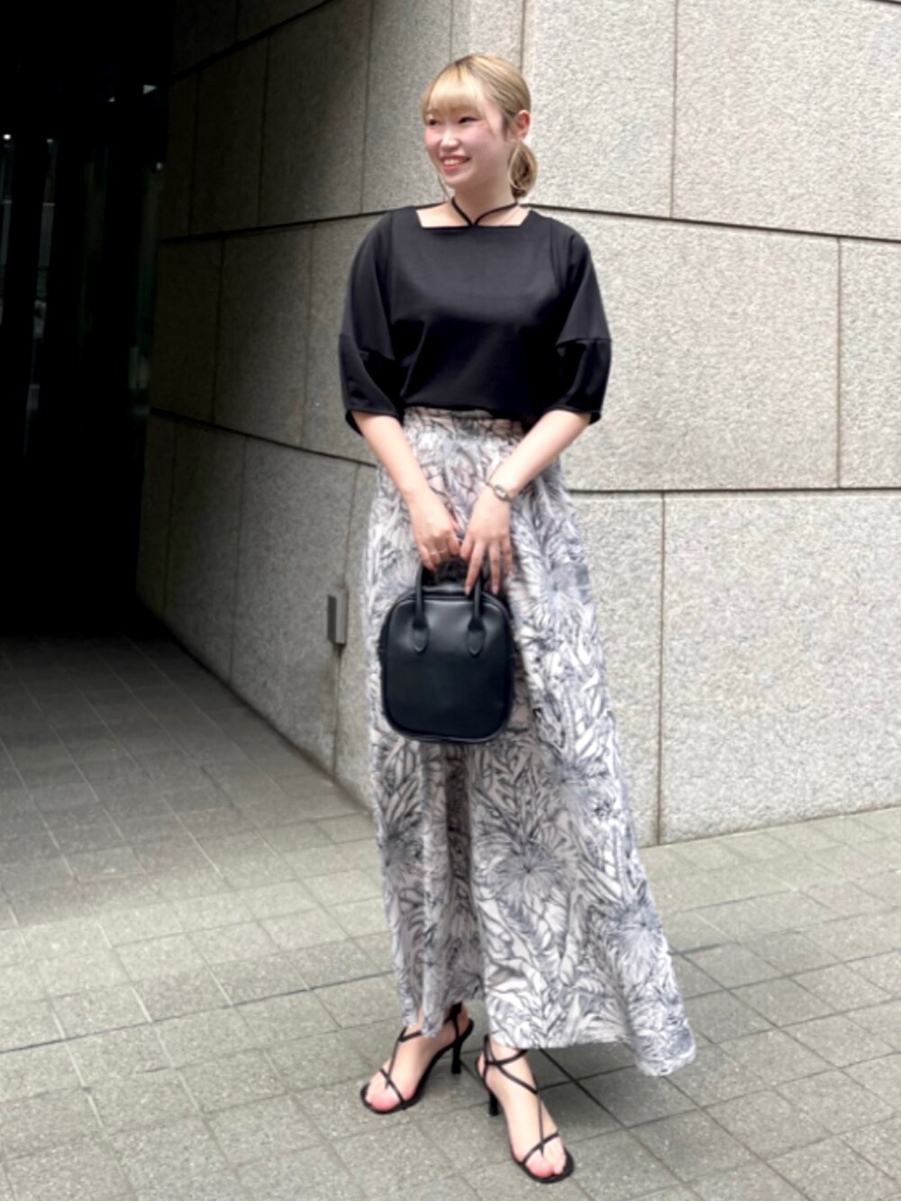 ブラック系のTシャツ/カットソー、ブルー系のスカートを着用したレディースの夏コーディネートの2枚目の写真