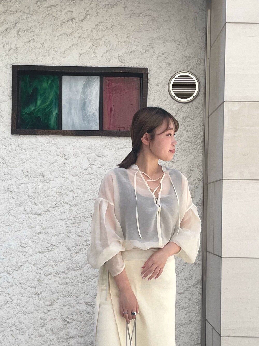 ホワイト系のシャツ/ブラウス、ベージュ系のスカートを着用したレディースの夏コーディネートの2枚目の写真