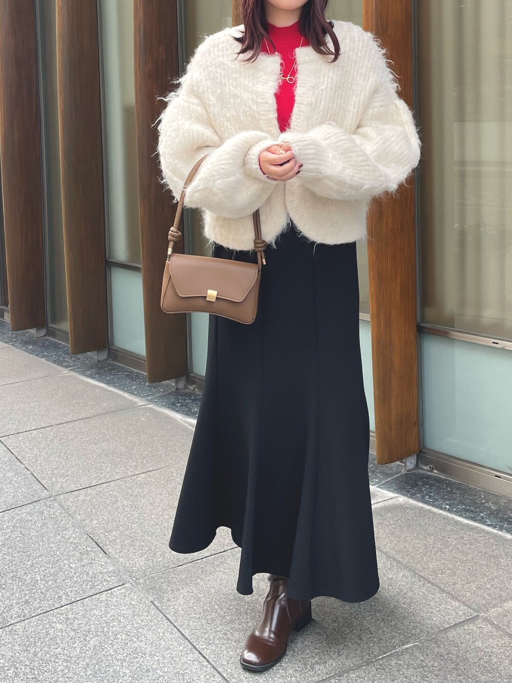 レッド系のニット/セーター、ホワイト系のカーディガン/ボレロを着用したレディースの冬コーディネートの3枚目の写真