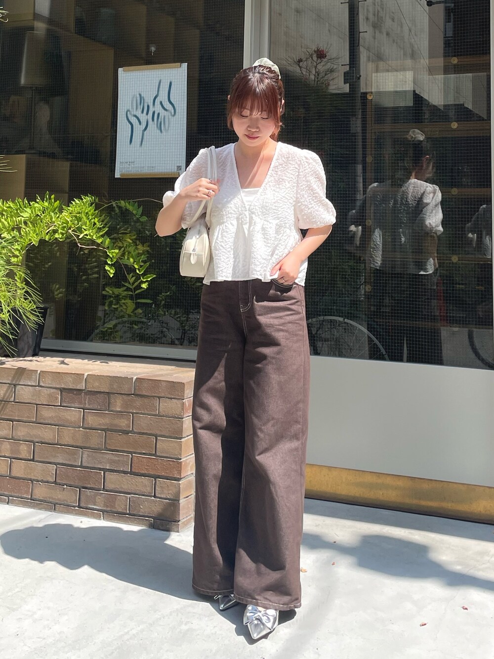 ホワイト系のシャツ/ブラウス、シルバー系のパンプスを着用したレディースの夏コーディネートの3枚目の写真