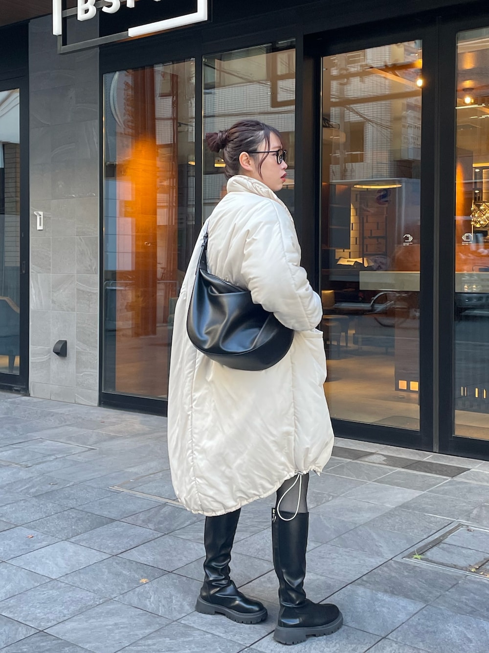 ホワイト系のダウンジャケット/コート、ブラック系のショルダーバッグ、その他のトップスを着用したレディースの冬コーディネートの3枚目の写真