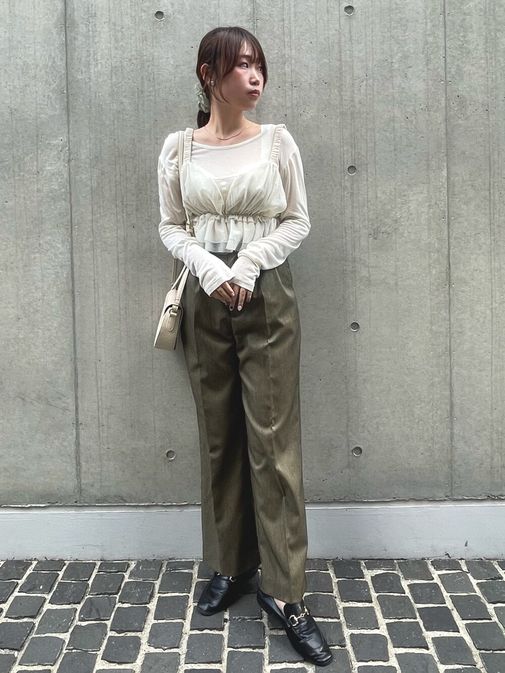 ブラウン系のスラックス、ホワイト系のキャミソールを着用したレディースの夏コーディネートの2枚目の写真