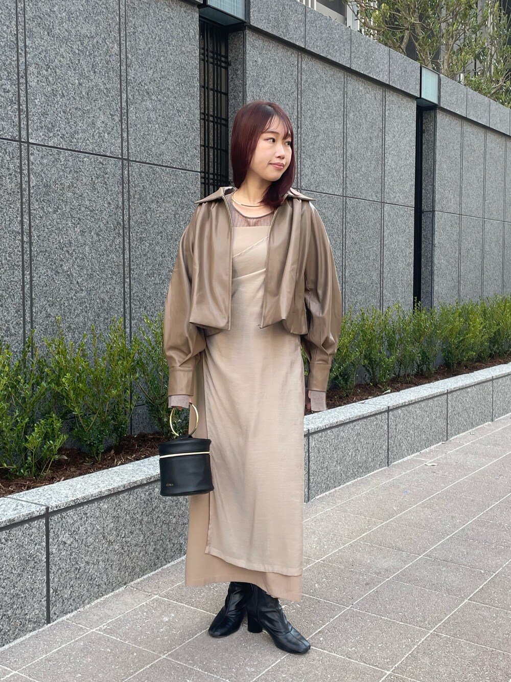 ベージュ系のブルゾン、ベージュ系のワンピース、ブラウン系のニット/セーターを着用したレディースの冬コーディネートの3枚目の写真