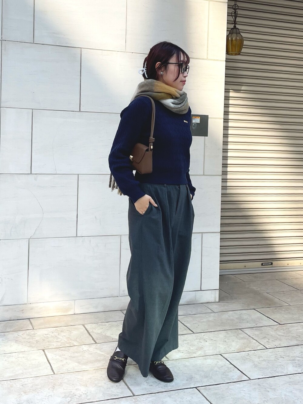 ブラウン系のローファー、ベージュ系のマフラーを着用したレディースの秋コーディネートの2枚目の写真