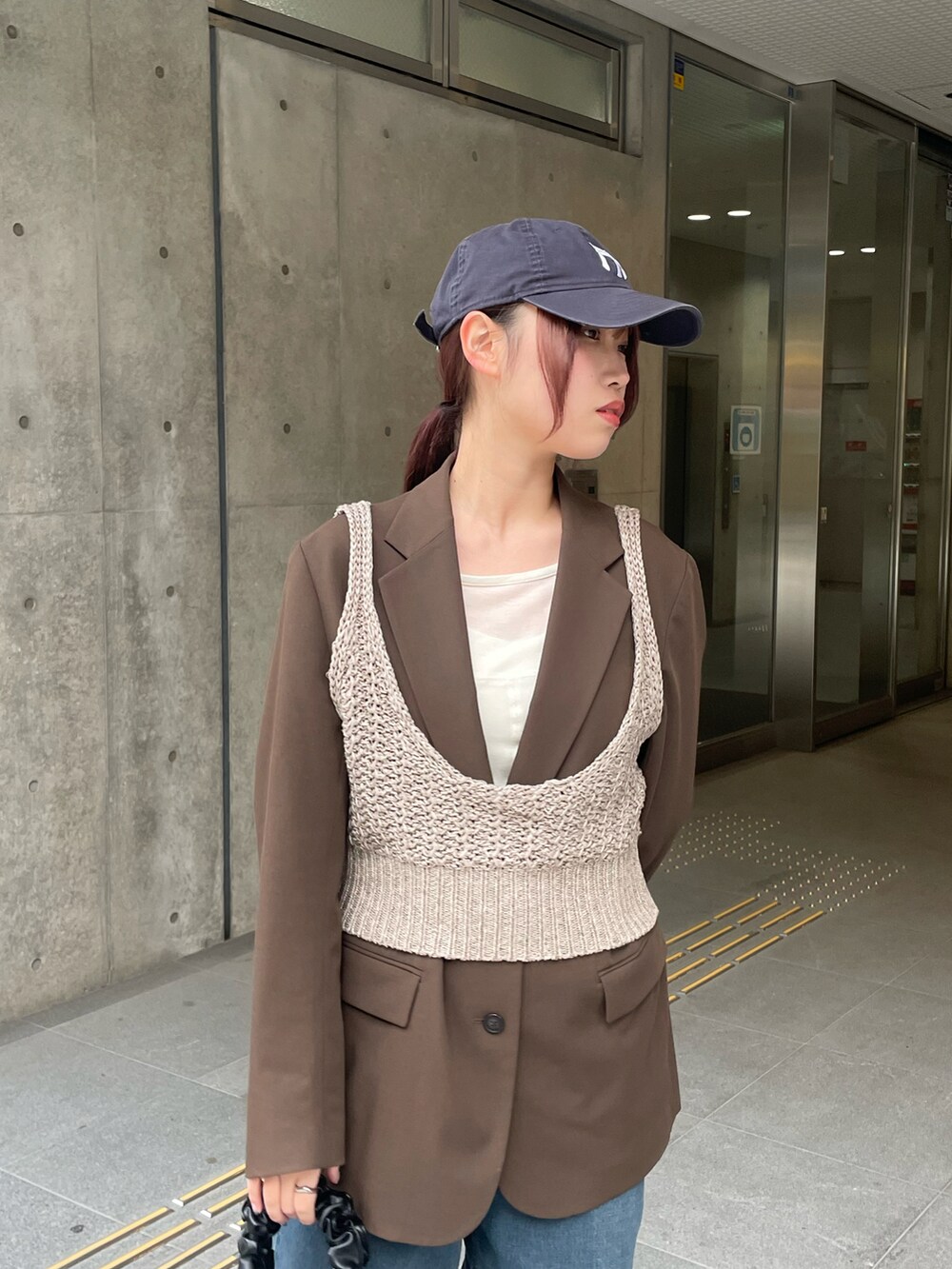 ブラウン系のニット/セーターを着用したレディースの冬コーディネートの3枚目の写真