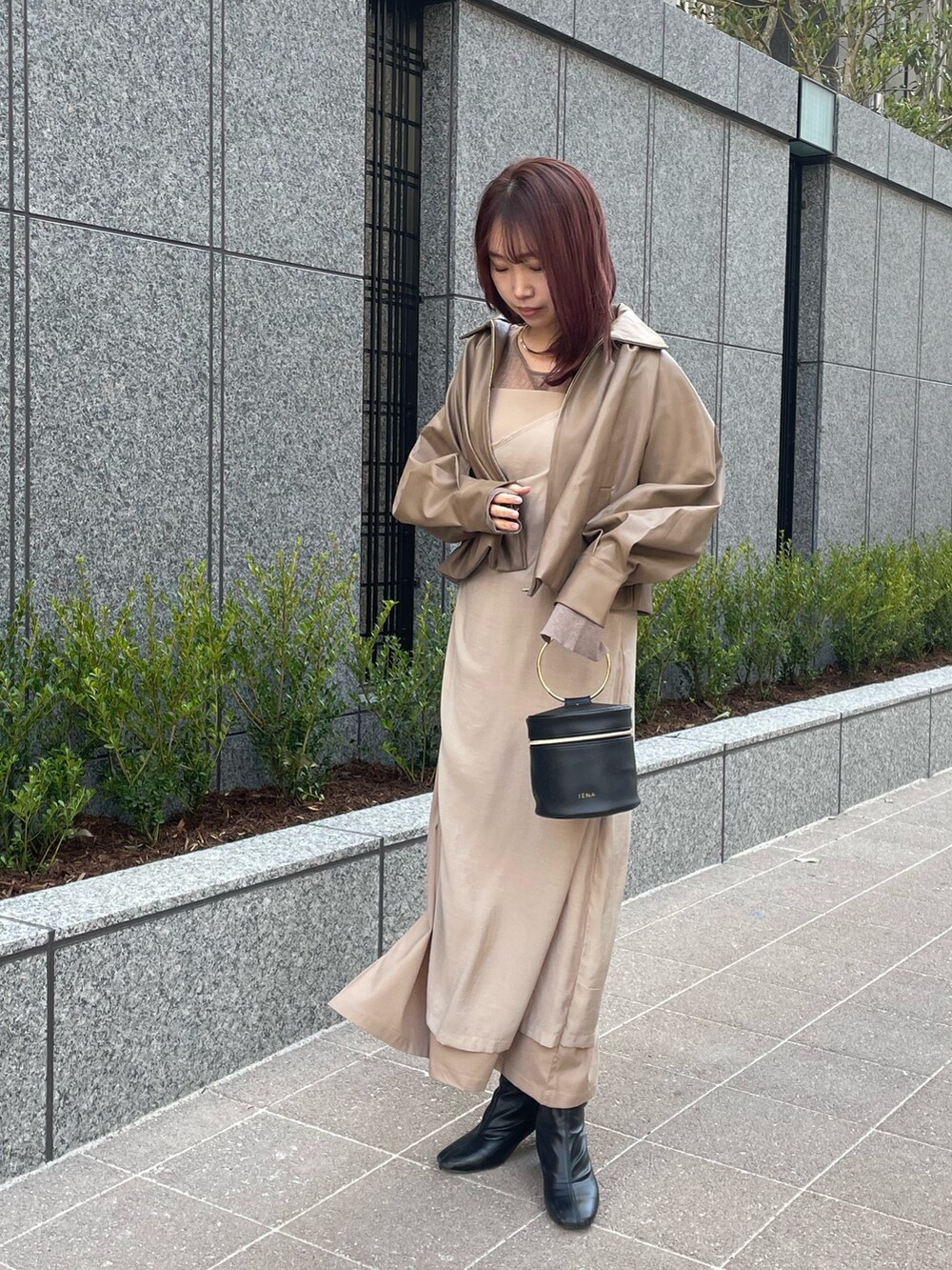 ベージュ系のブルゾン、ベージュ系のワンピース、ブラウン系のニット/セーターを着用したレディースの冬コーディネートの2枚目の写真