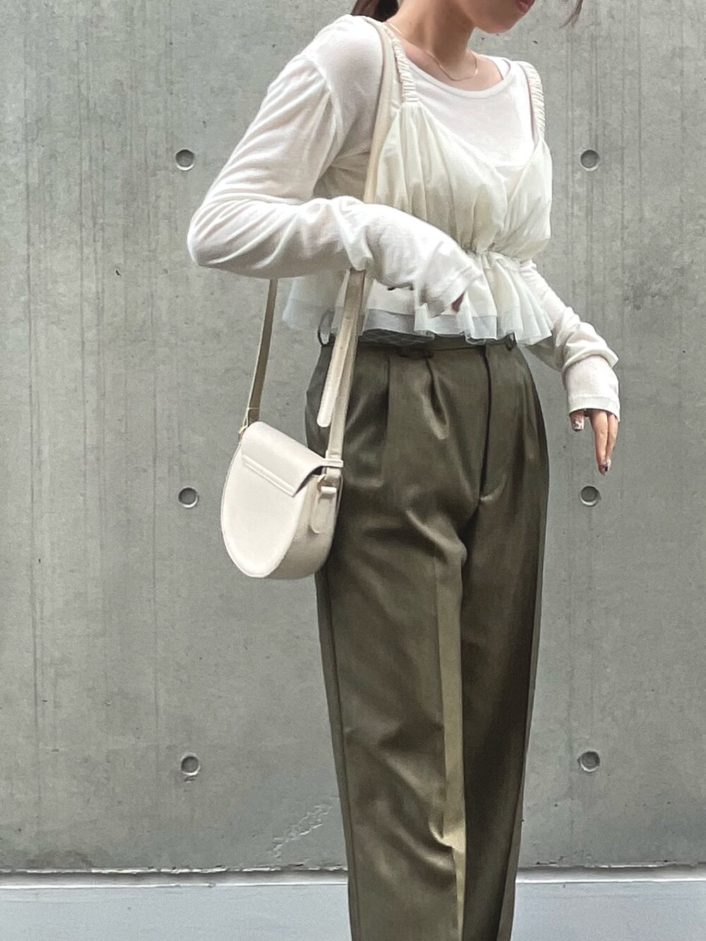 ブラウン系のスラックス、ホワイト系のキャミソールを着用したレディースの夏コーディネートの4枚目の写真