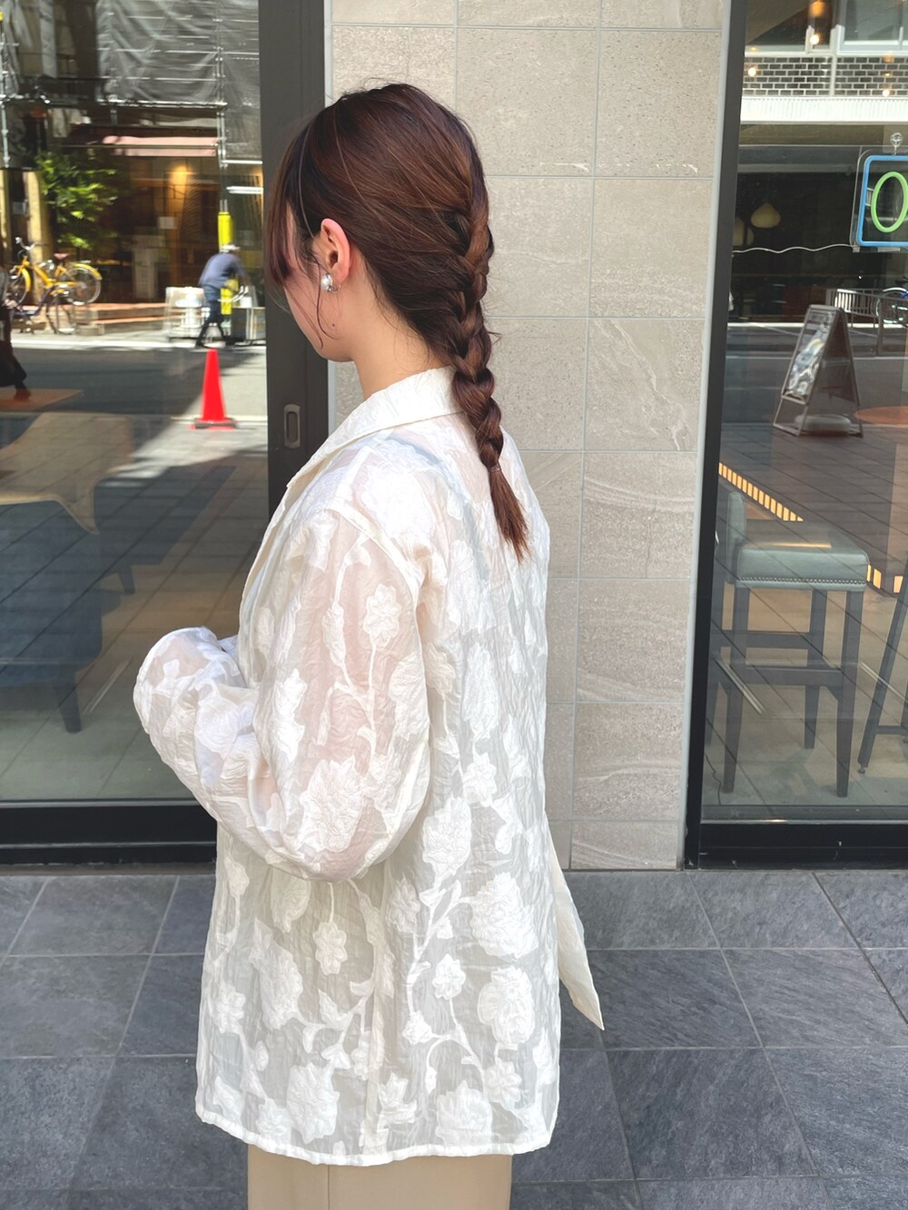 ホワイト系のテーラードジャケット、ベージュ系のドレスを着用したレディースの秋コーディネートの5枚目の写真