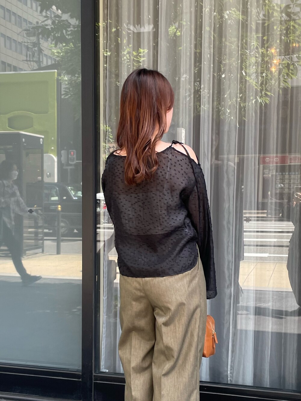 ブラック系のシャツ/ブラウス、ブラウン系のスラックスを着用したレディースの秋コーディネートの2枚目の写真