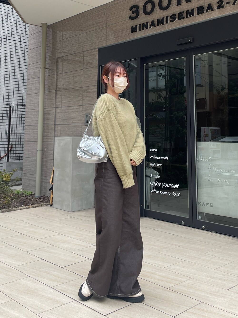 グリーン系のニット/セーターを着用したレディースの春コーディネートの3枚目の写真