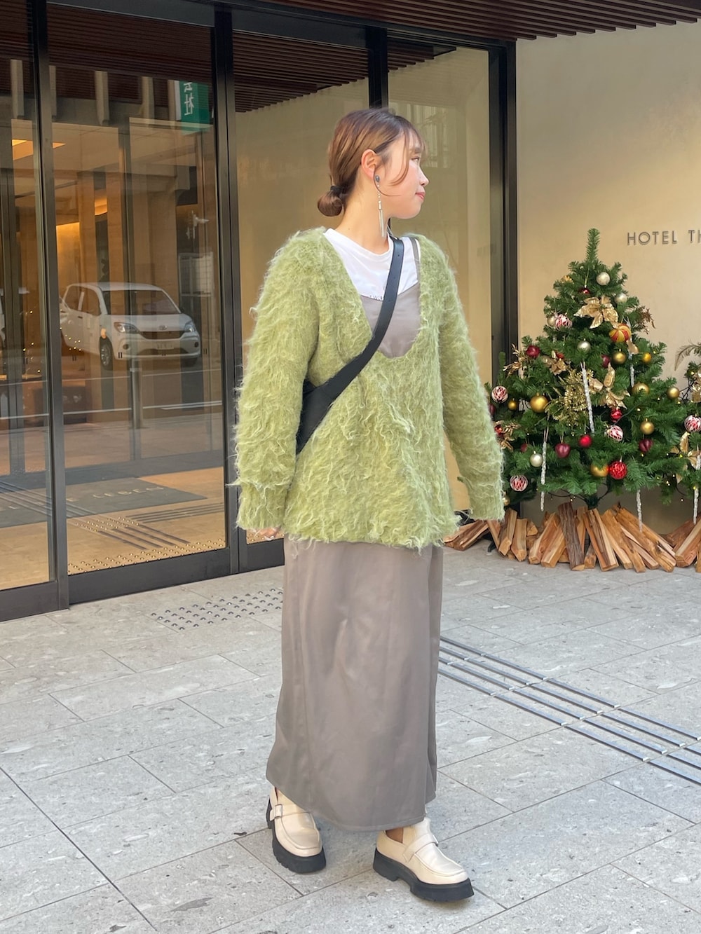 グリーン系のニット/セーター、ホワイト系のブーツを着用したレディースの秋コーディネートの2枚目の写真