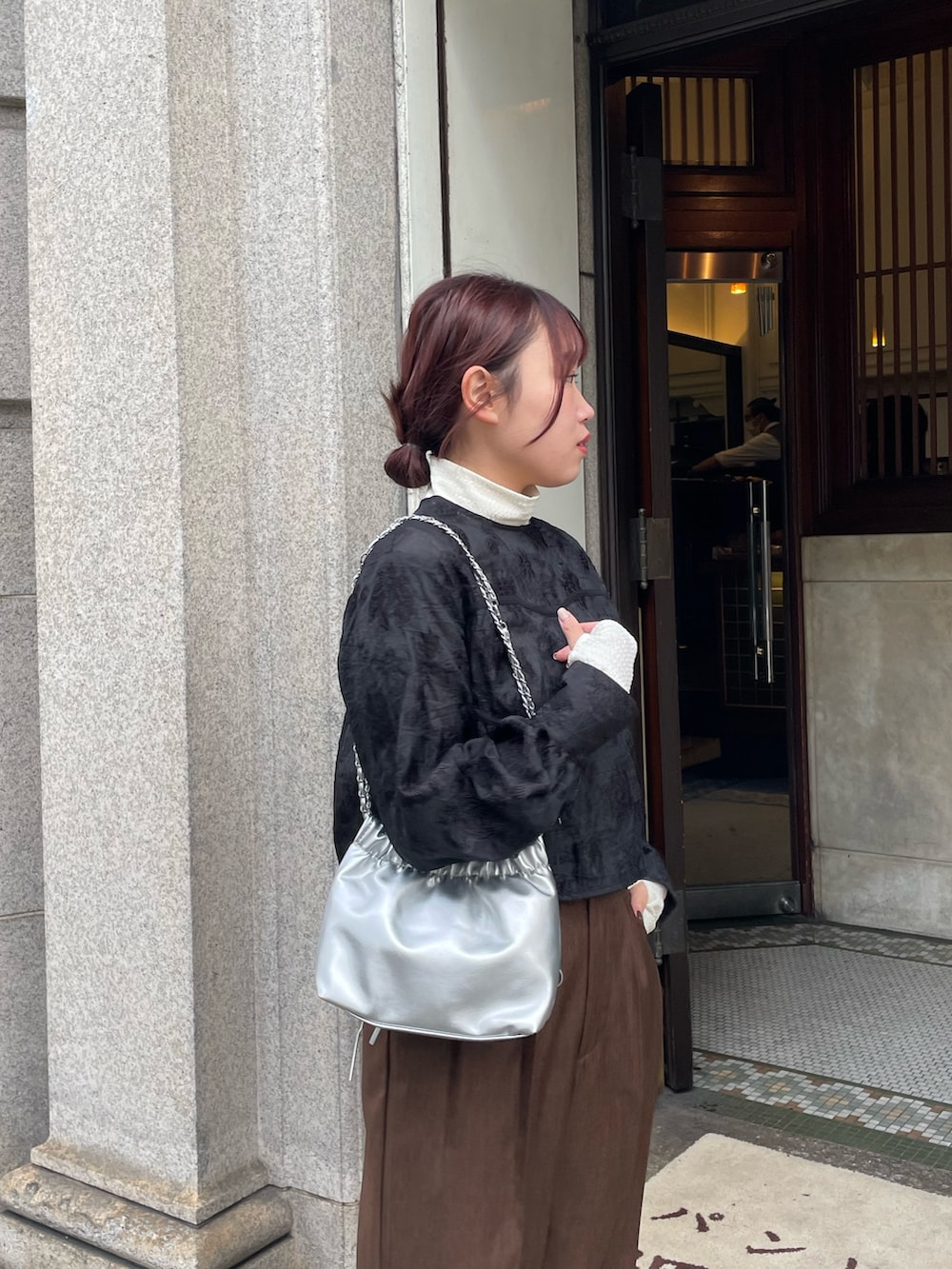 ホワイト系のTシャツ/カットソー、ブラウン系のスラックス、ブラック系のシャツ/ブラウスを着用したレディースの冬コーディネートの3枚目の写真