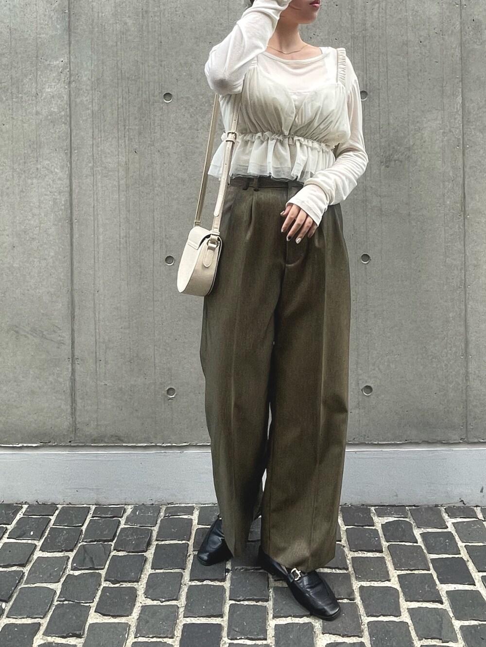 ブラウン系のスラックス、ホワイト系のキャミソールを着用したレディースの夏コーディネートの3枚目の写真