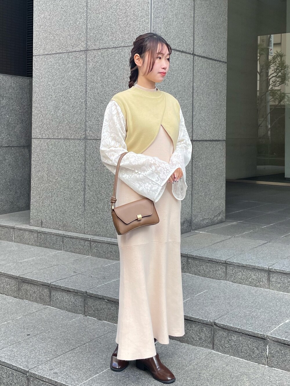 グリーン系のニット/セーター、ホワイト系のワンピースを着用したレディースの冬コーディネートの2枚目の写真