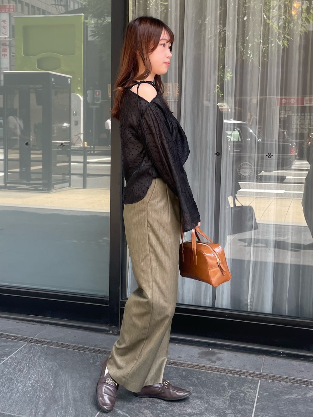 ブラック系のシャツ/ブラウス、ブラウン系のスラックスを着用したレディースの秋コーディネートの3枚目の写真