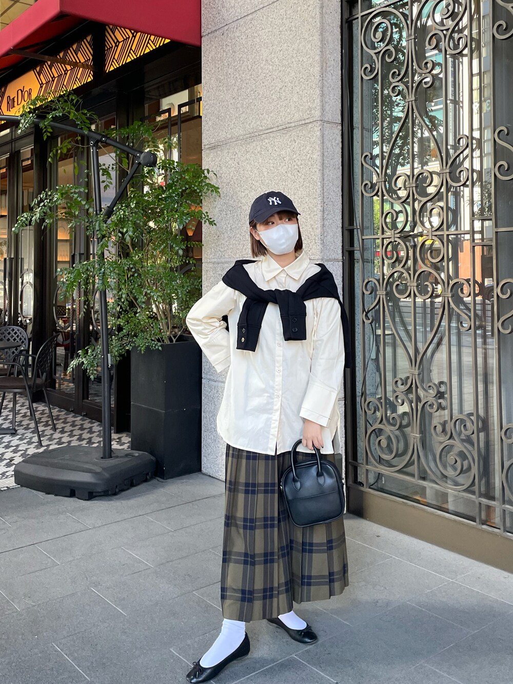 ホワイト系のシャツ/ブラウス、ブラック系のキャップを着用したレディースの秋コーディネートの2枚目の写真