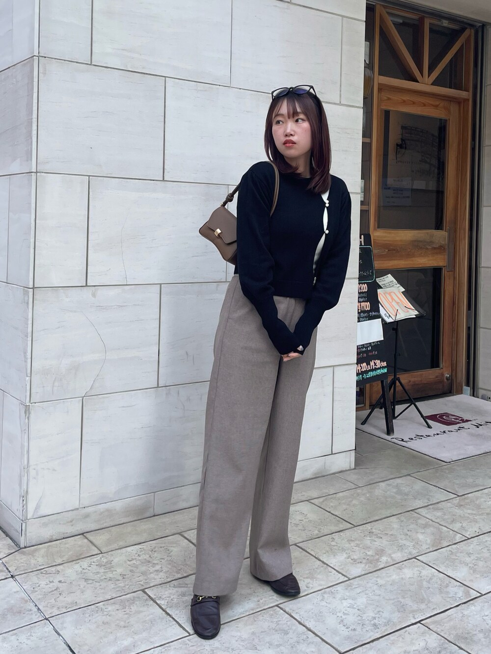 ブラック系のニット/セーター、ブラウン系のローファー、ベージュ系のその他パンツを着用したレディースの冬コーディネートの2枚目の写真