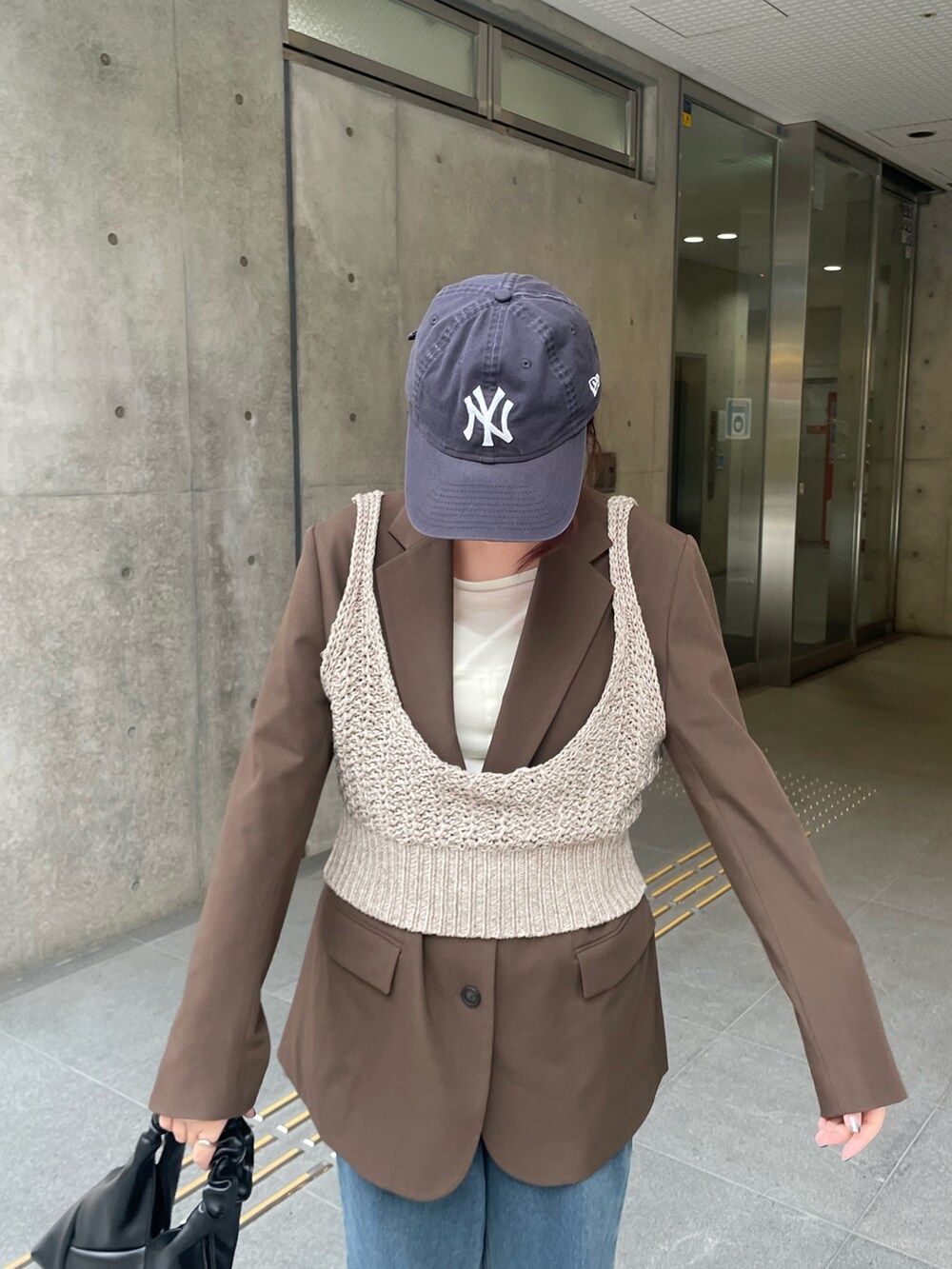 ブラウン系のニット/セーターを着用したレディースの冬コーディネートの4枚目の写真