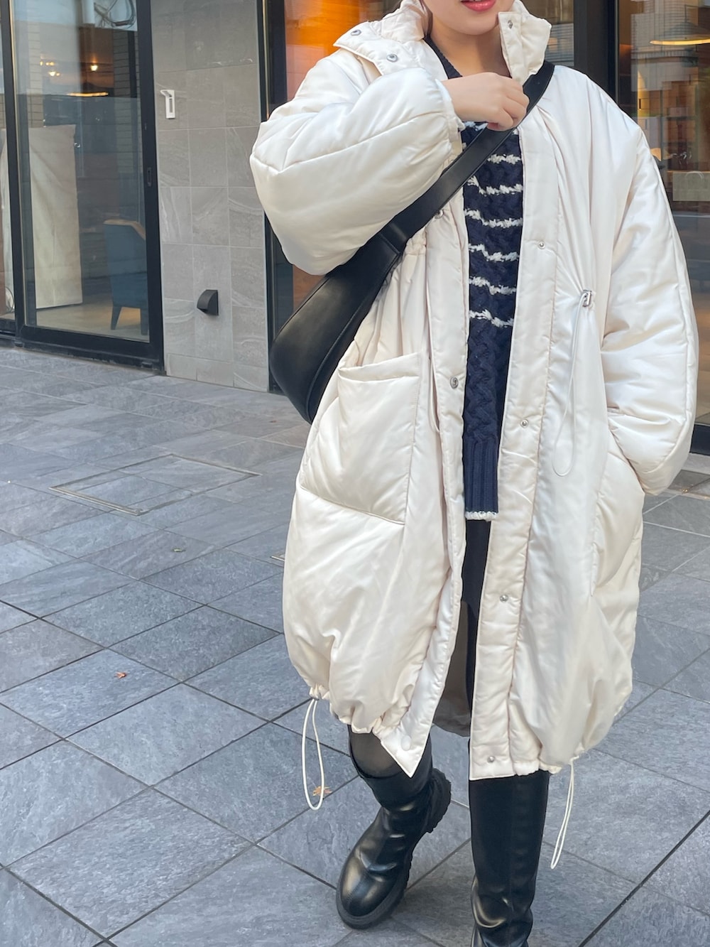 ホワイト系のダウンジャケット/コート、ブラック系のショルダーバッグ、その他のトップスを着用したレディースの冬コーディネートの5枚目の写真