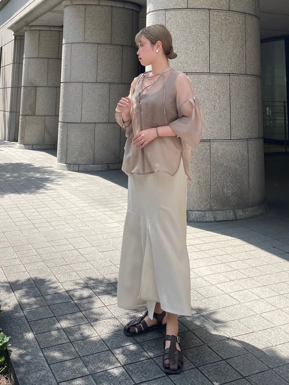 ブラウン系のシャツ/ブラウスを着用したレディースの夏コーディネートの2枚目の写真