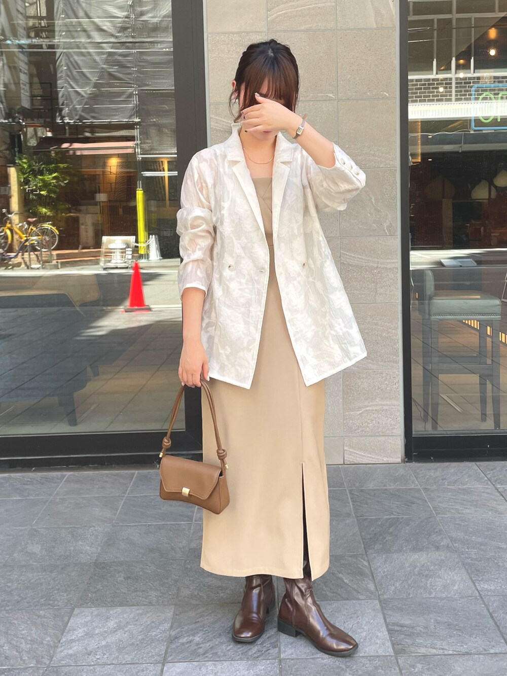 ホワイト系のテーラードジャケット、ベージュ系のドレスを着用したレディースの秋コーディネートの3枚目の写真