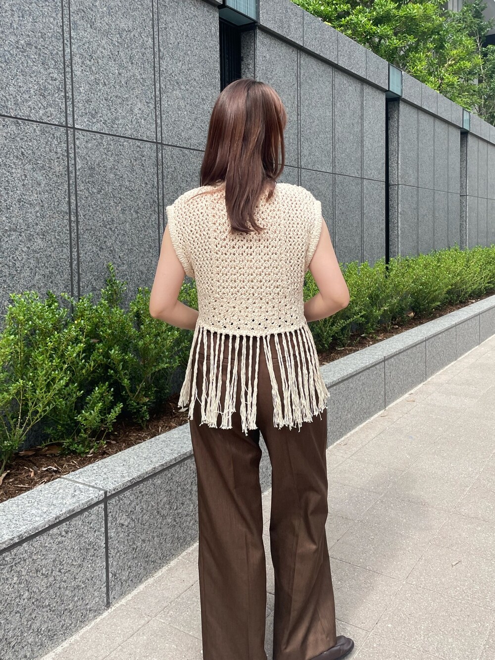 ブラウン系のスラックス、ベージュ系のベストを着用したレディースの夏コーディネートの5枚目の写真