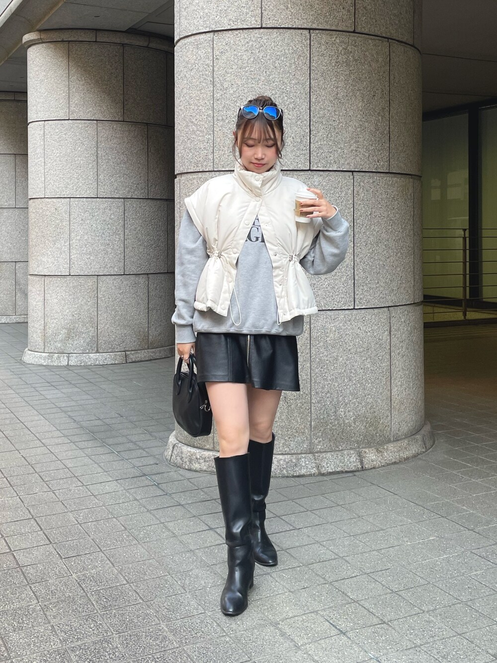 ホワイト系のダウンジャケット/コート、グレー系のスウェット、ブラック系のブーツを着用したレディースの秋コーディネートの2枚目の写真